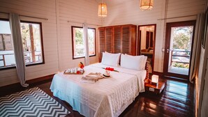 Un dormitorio con cama, mesita de noche y ventana.