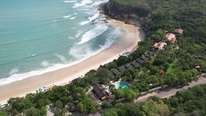 Vista aérea de un complejo turístico con piscina, sombrillas de playa y diversas opciones de alojamiento.