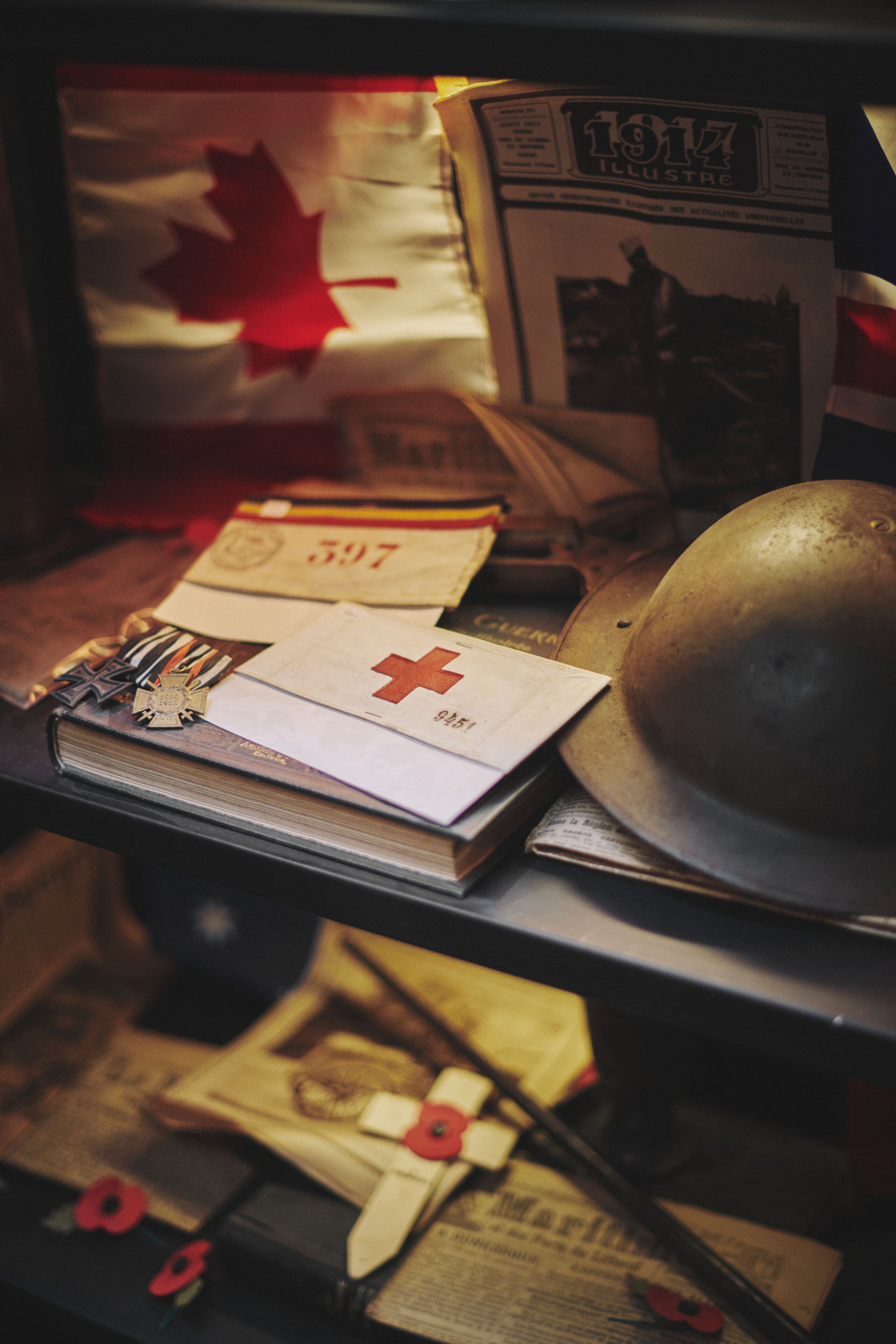 A collection of medals, a Canadian flag, and a helmet on a table.