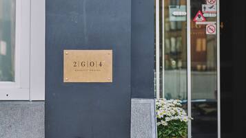 Entrada de un edificio con un letrero que dice "99" y "Quality Hostel 2G104".