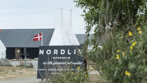 A sign for 'NORDLI' in Bornholm, mentioning amenities like a cafe, veal, safari camp, and a hotel.