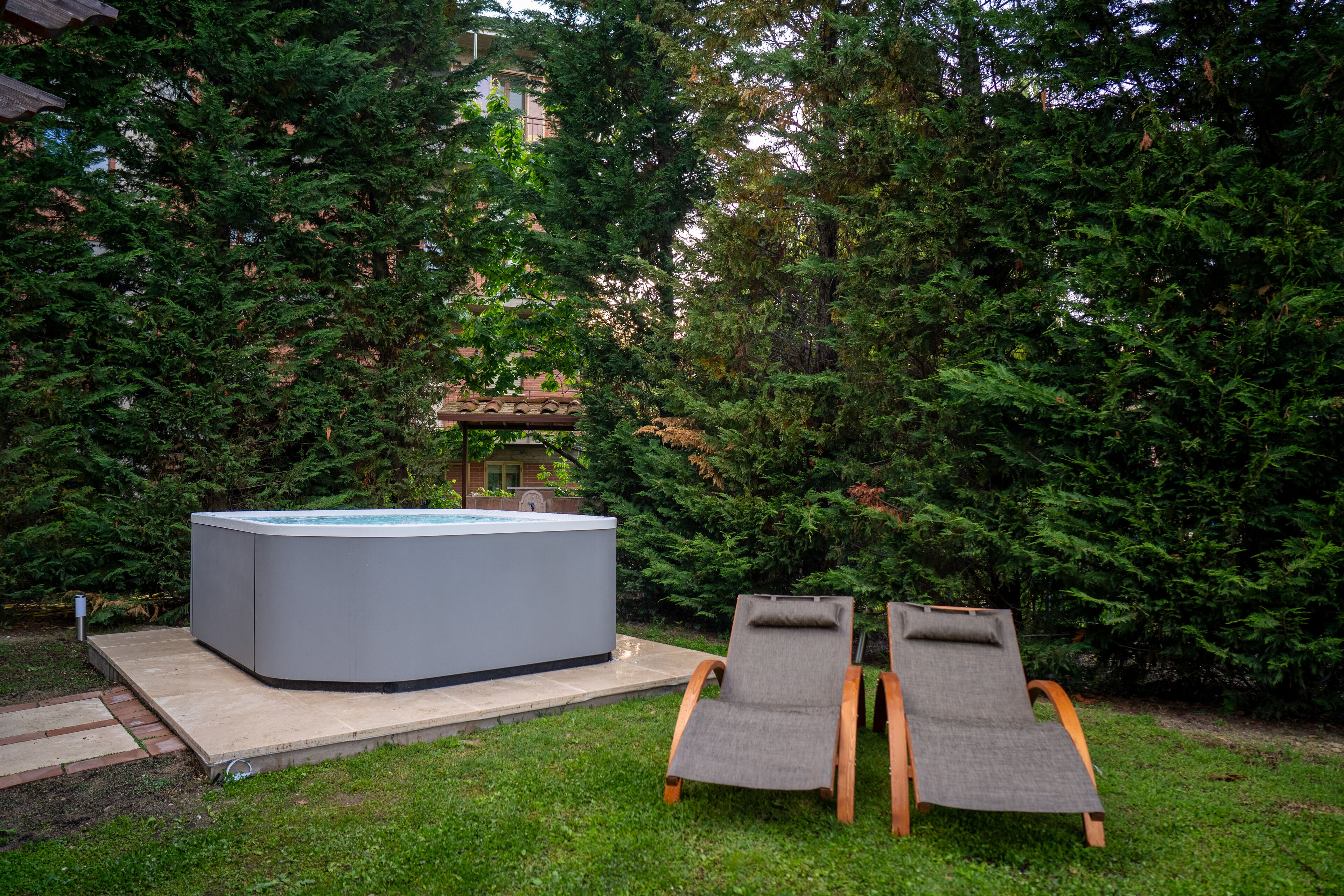 Un jacuzzi con dos sillones de jardín.