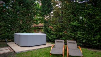 Un jacuzzi con dos sillones de jardín.