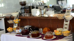A buffet table with various food items and condiments.
