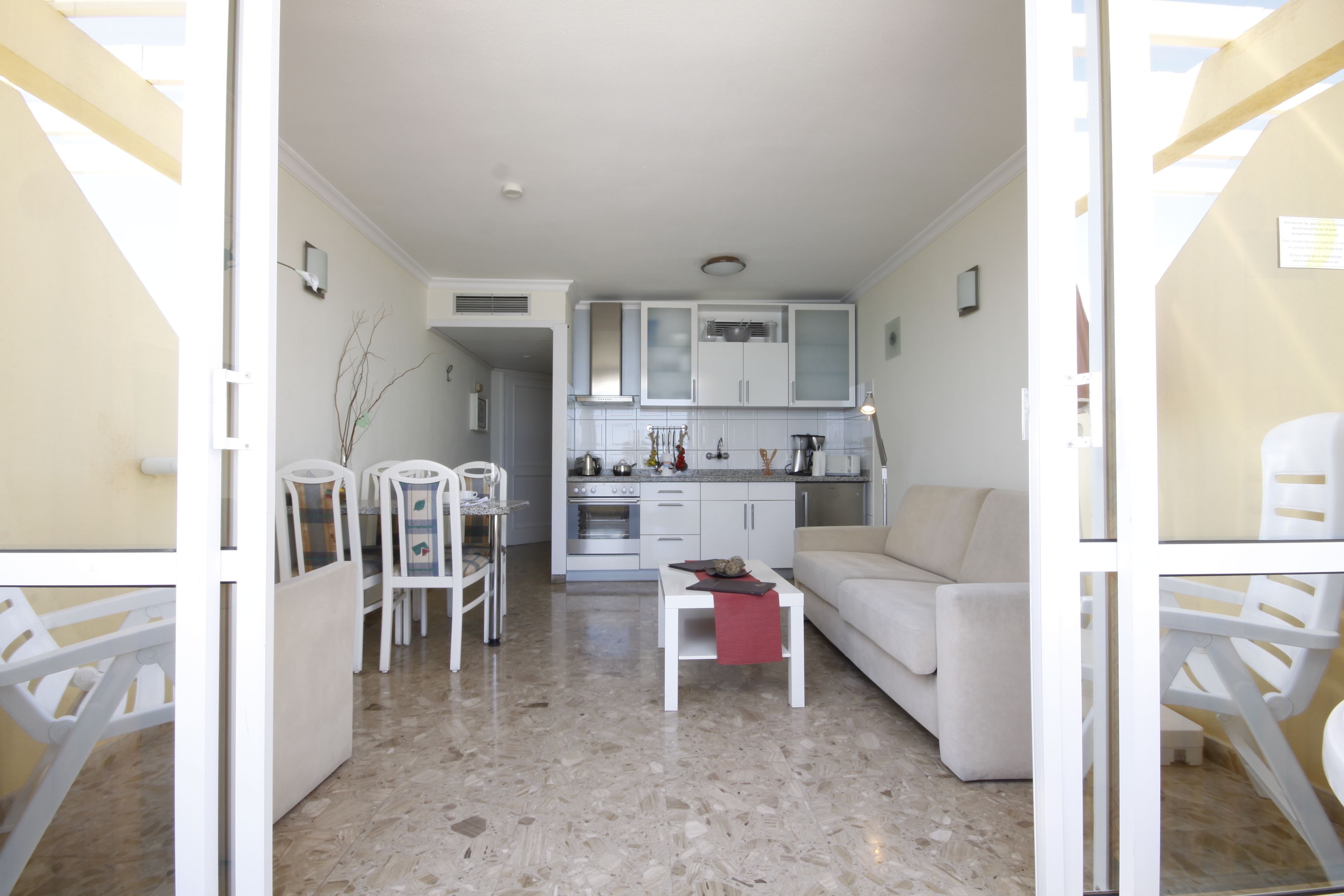 Un espacio habitable compacto con kitchenette, comedor y zona de estar.