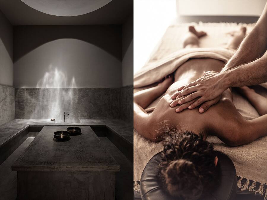 A spa room with a steam shower, a massage table, and a small table with bowls.