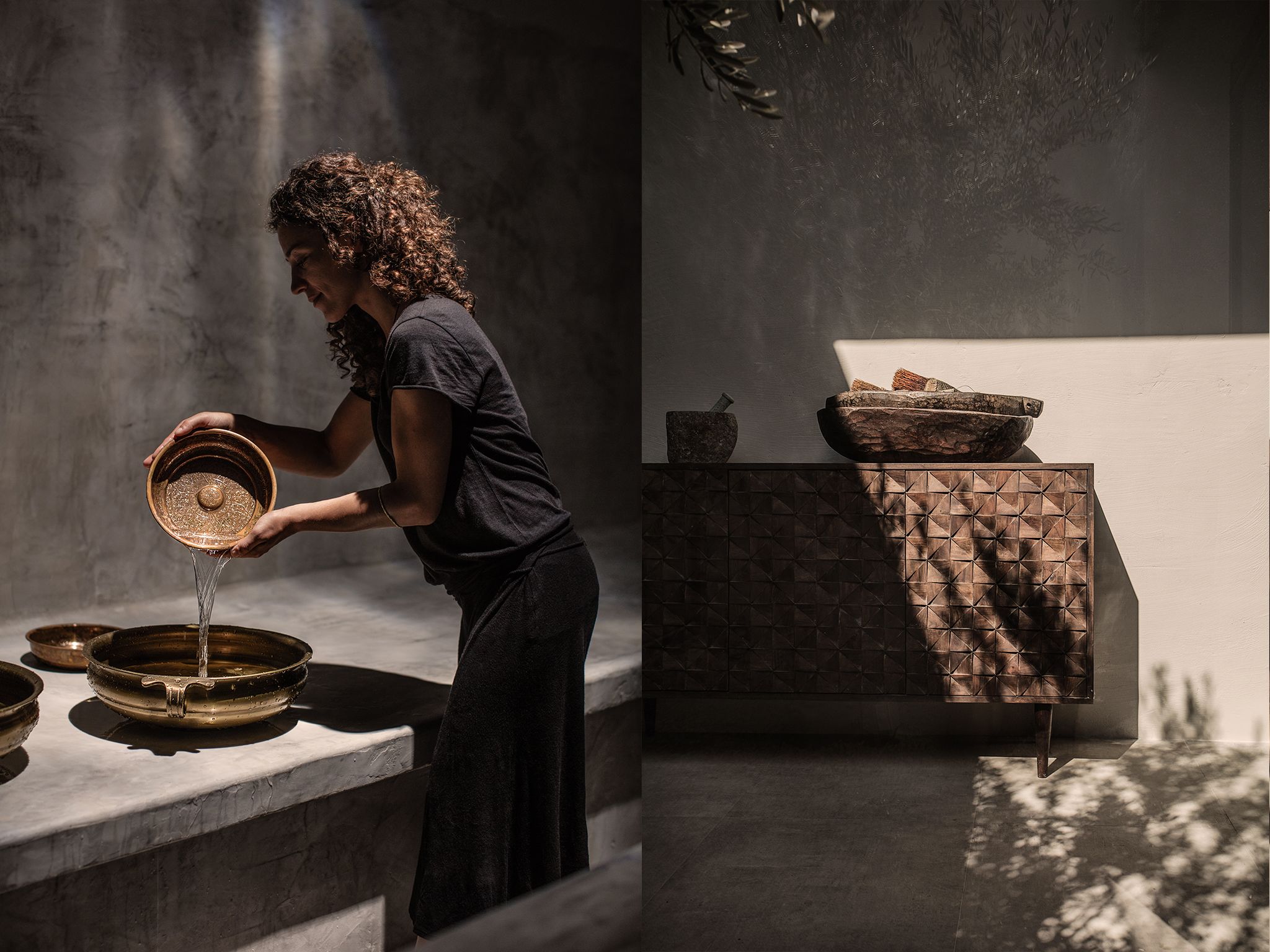 Una persona vierte agua de un cuenco a una palangana. Hay dos cuencos sobre una mesa, uno con tapa y otro sin. La habitación tiene una pared con textura y un suelo estampado.