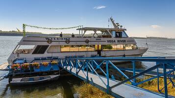 Un bote llamado 'Welcome' atracado en un muelle con un puente azul.