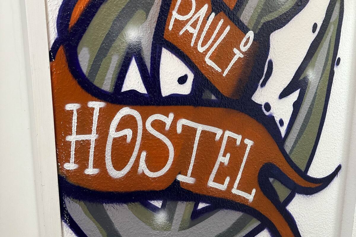 A wall with graffiti art featuring the words "PAULI HOSTEL".