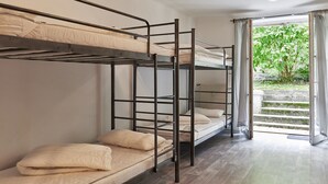 Habitación con literas y vistas a un jardín a través de un ventanal.
