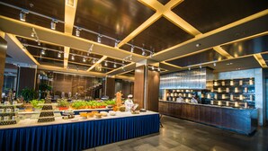 A buffet setup with a variety of food items and a chef preparing food. - Arcadia seaside holiday hotel Beidaihe (Qinhuangdao)