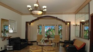 A spacious lobby with a high ceiling, a chandelier, and a large stained glass window. There are multiple seating areas with sofas and armchairs. - Tamareiras Park Hotel (Uberaba)