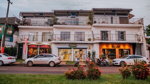 A multi-story building with various shops on the ground floor, including a restaurant and a store named 'La Trattoria'. - Pousada Beira Rio (Itumbiara)