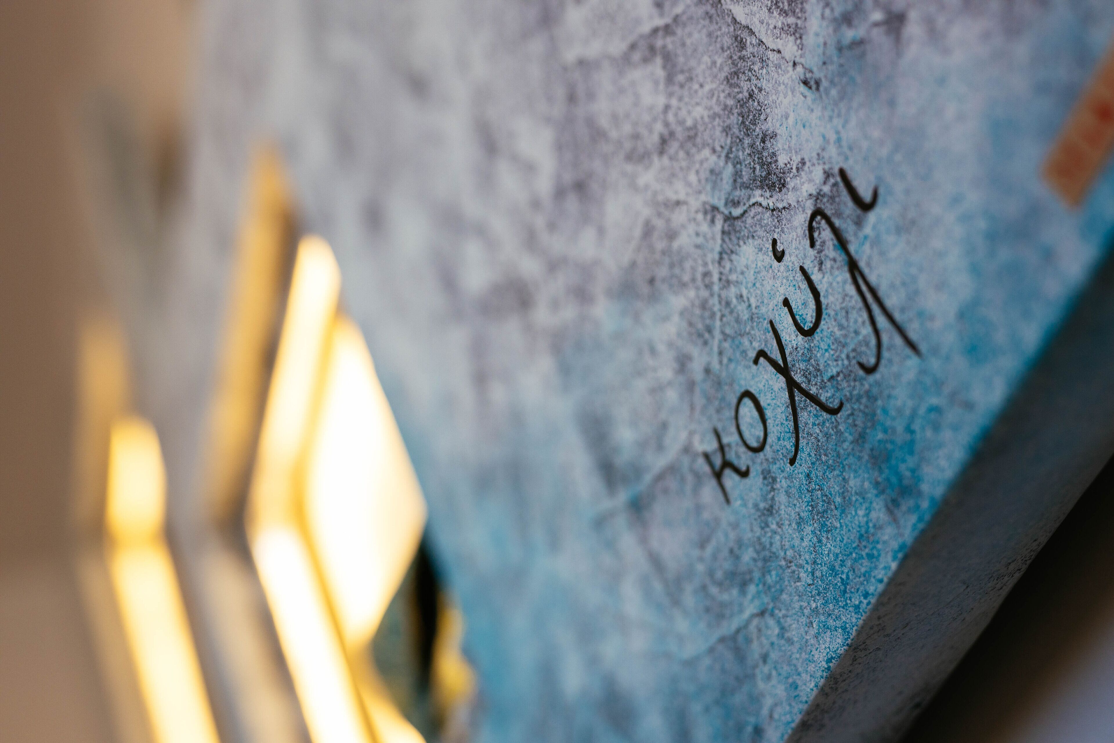 A close-up of a textured wall with the inscription "KUKA" in a stylized font.