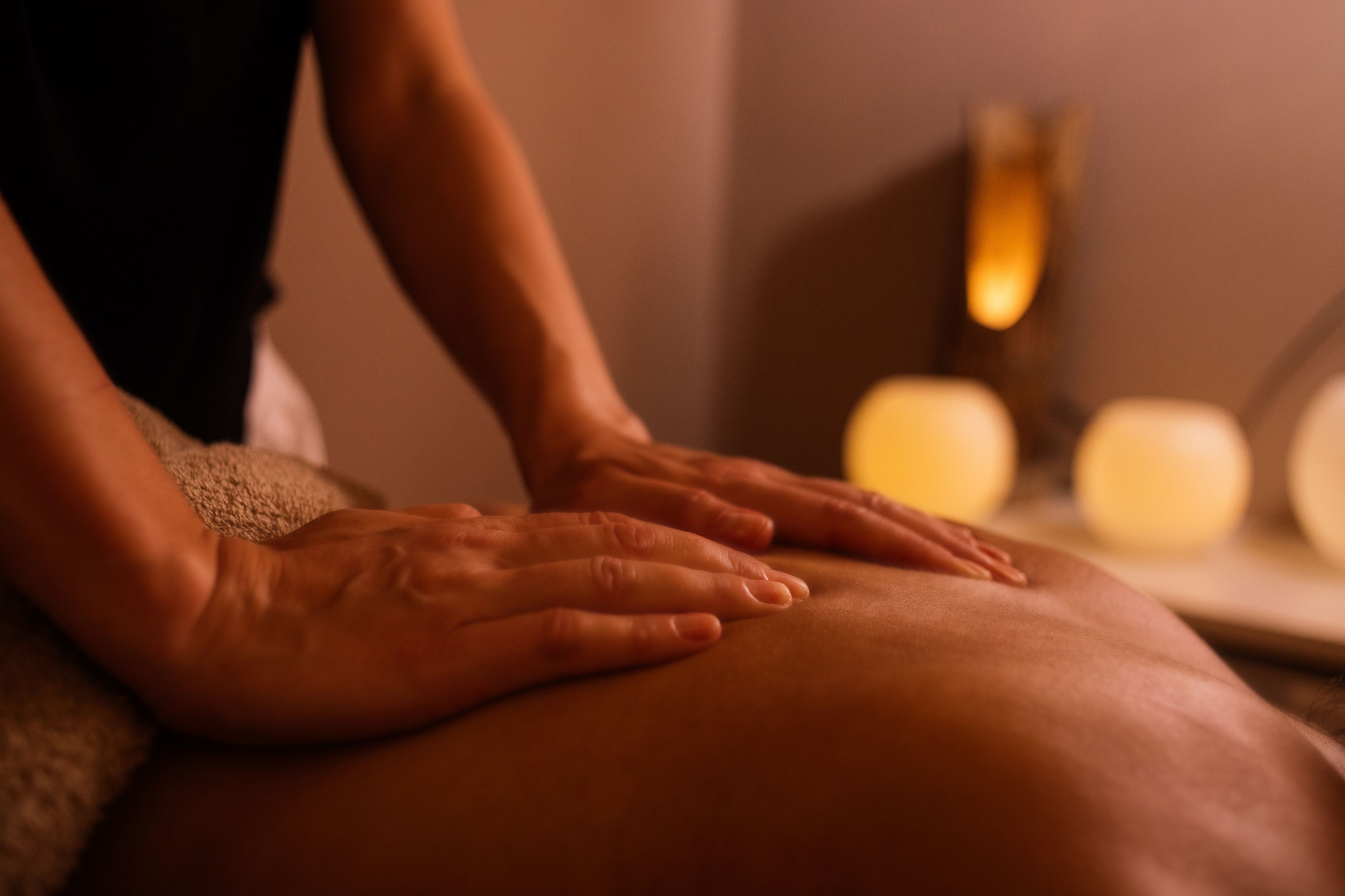 A close-up of hands performing a massage on a person's leg.