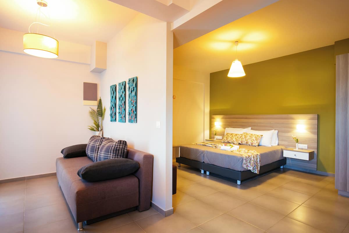 Ein modernes Schlafzimmer mit Bett, Nachttisch und einer Couch.