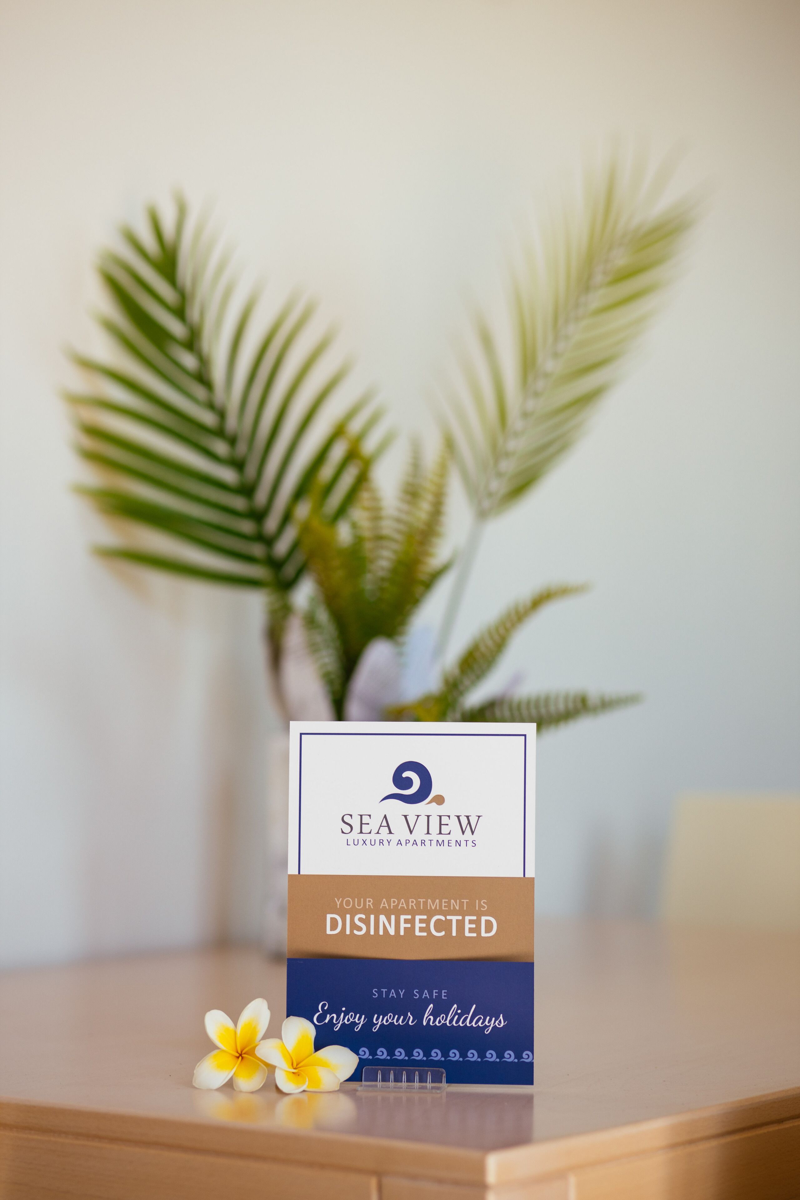 A sign indicating the apartment is disinfected, with a logo for Sea View Luxury Apartments.