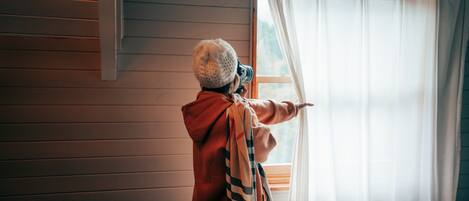 A person adjusting a window blind.