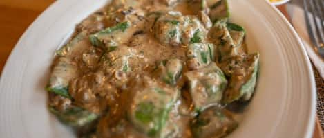 A plate of food with a creamy sauce and green vegetables.