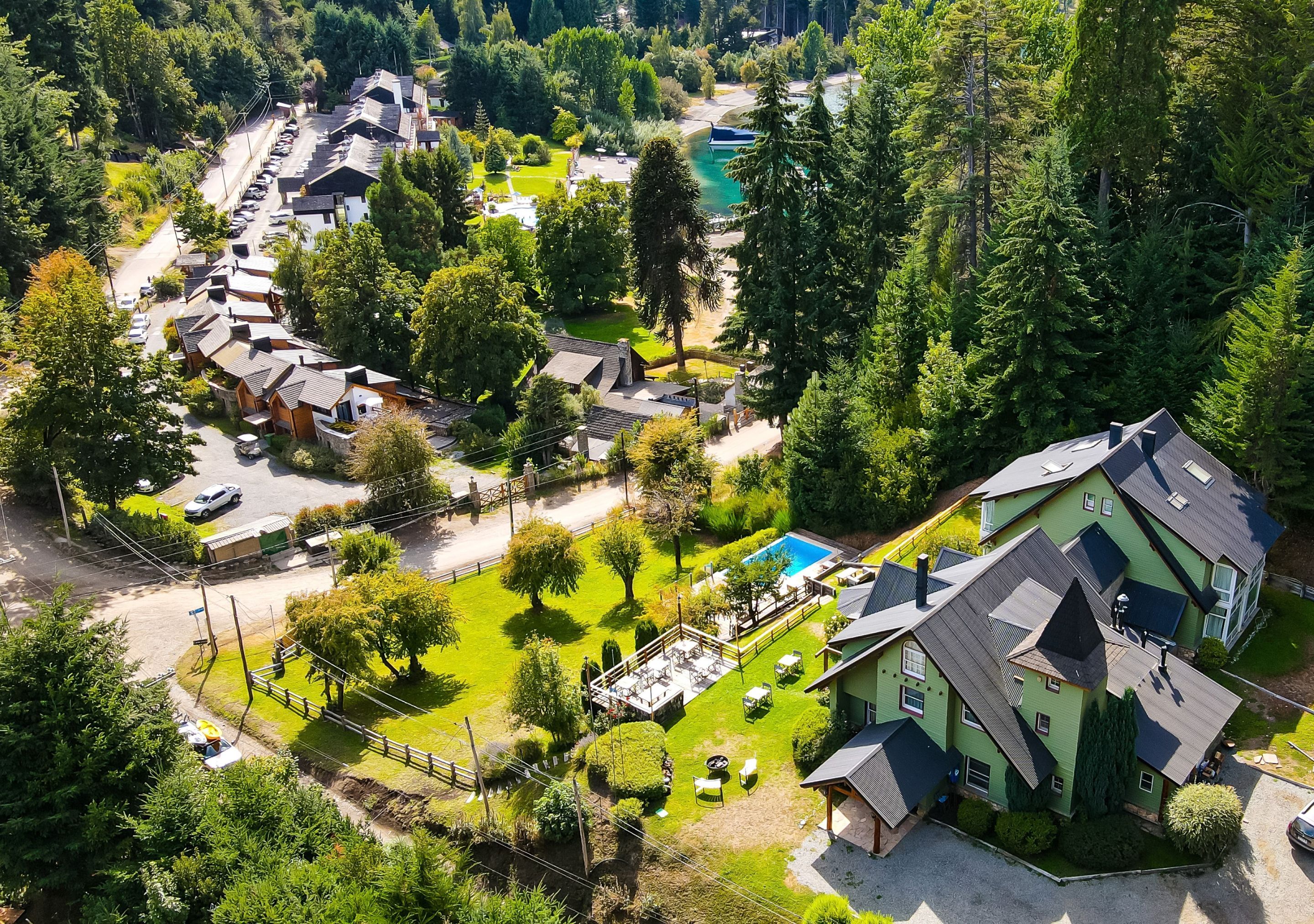 Área residencial com casas, piscina e gramado bem cuidado.
