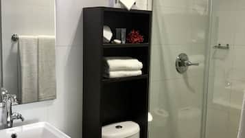 Une salle de bain moderne avec un lavabo blanc, des toilettes et une douche à parois de verre.