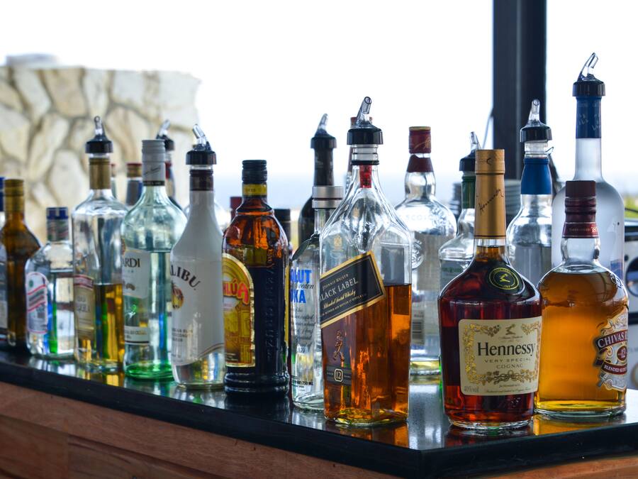 A variety of liquor bottles displayed on a bar counter.