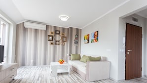 Un salon moderne avec un canapé, une table basse et des œuvres d’art décoratives au mur.