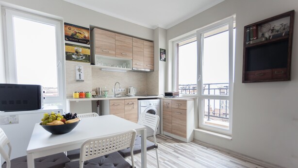 Une cuisine moderne avec un coin repas, un lave-linge et une grande fenêtre.
