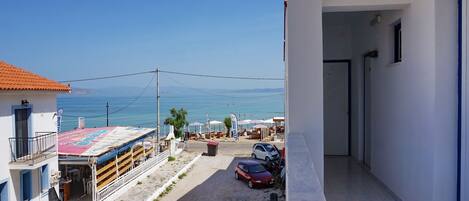 Une vue sur la côte, avec un bâtiment doté d’un balcon, d’un espace extérieur couvert aménagé en coin salon et offrant une vue dégagée sur la mer.
