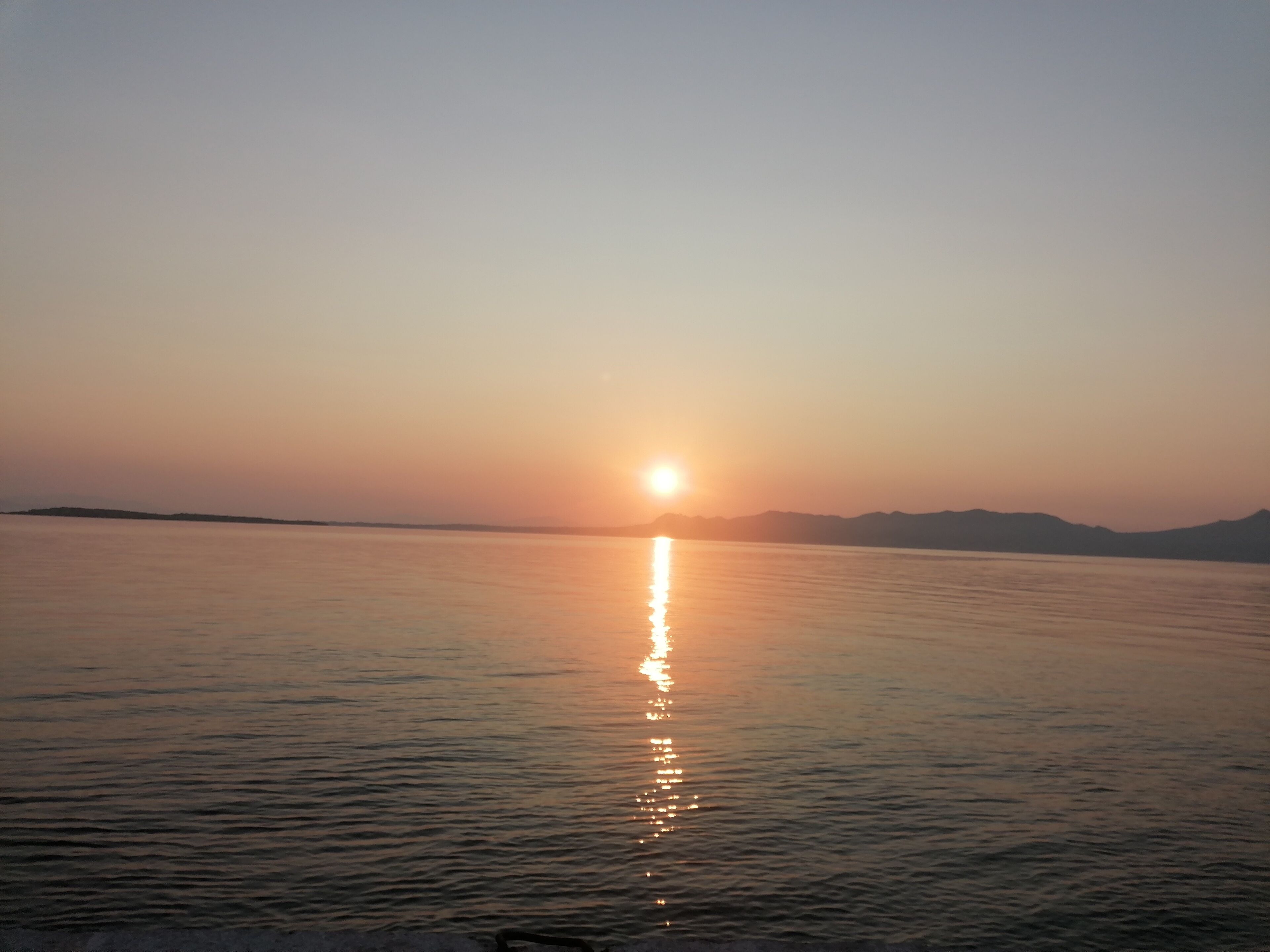 A calm body of water reflecting the sun.