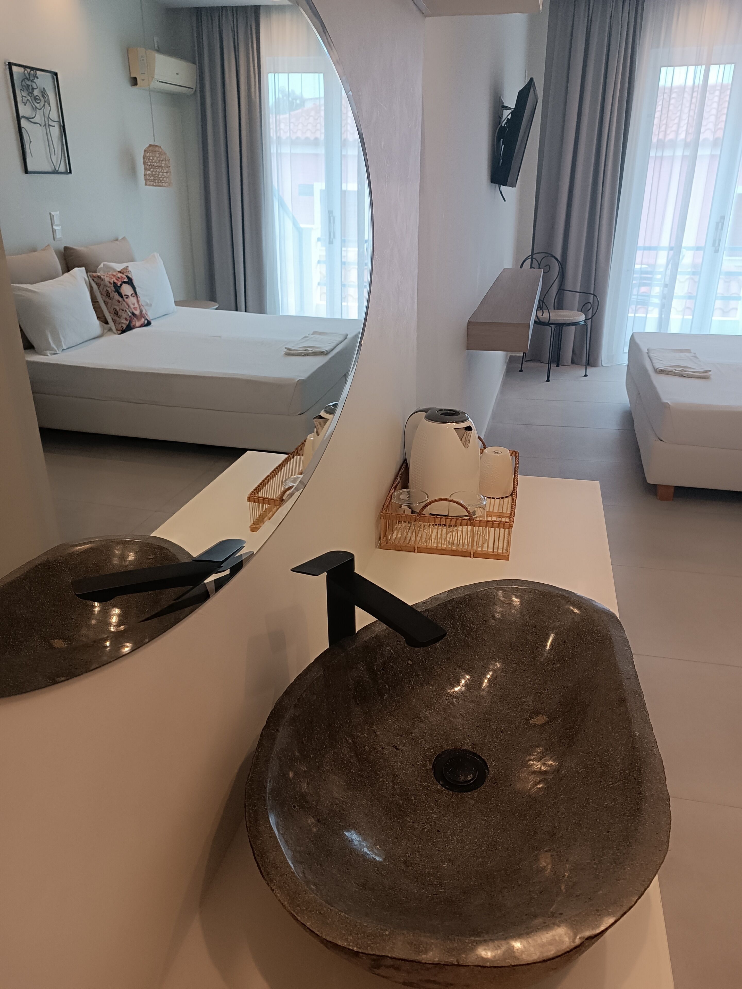 A modern bathroom with a large, round, brown sink, a mirror, and a white countertop.