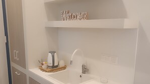 A modern bathroom with a white sink, a towel rack, and a decorative welcome sign. - Akrogiali Hotel (Agistri)