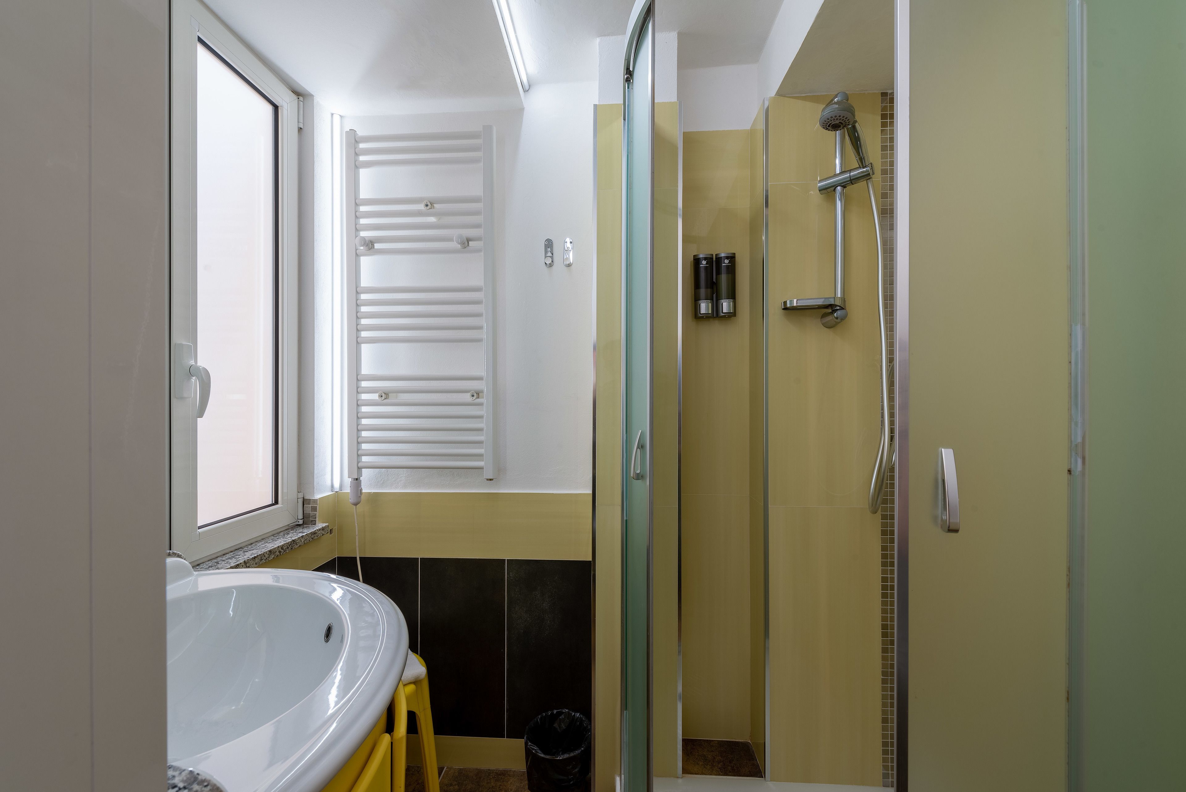 A bathroom with a bathtub, a glass-enclosed shower, and a toilet.
