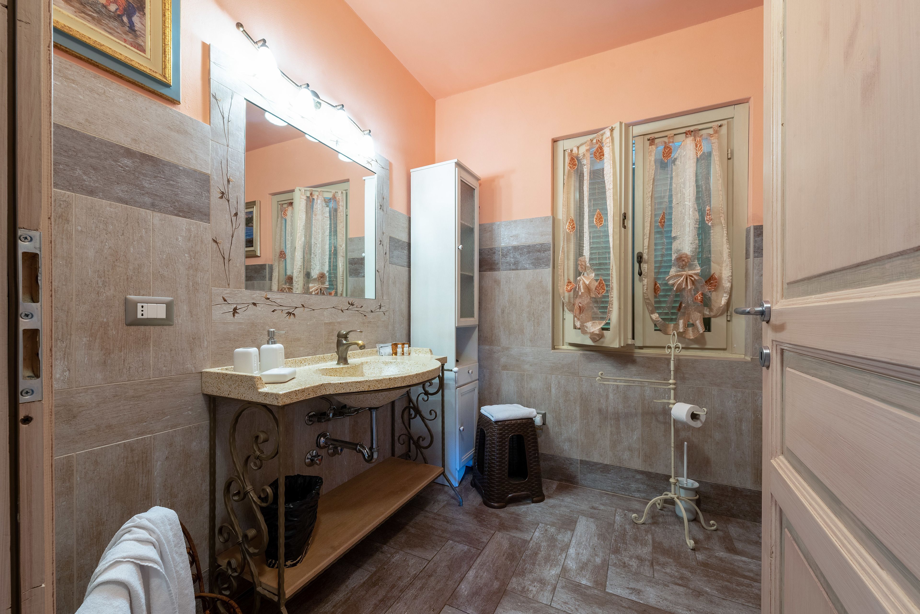 A bathroom with a vanity, sink, mirror, and toilet.