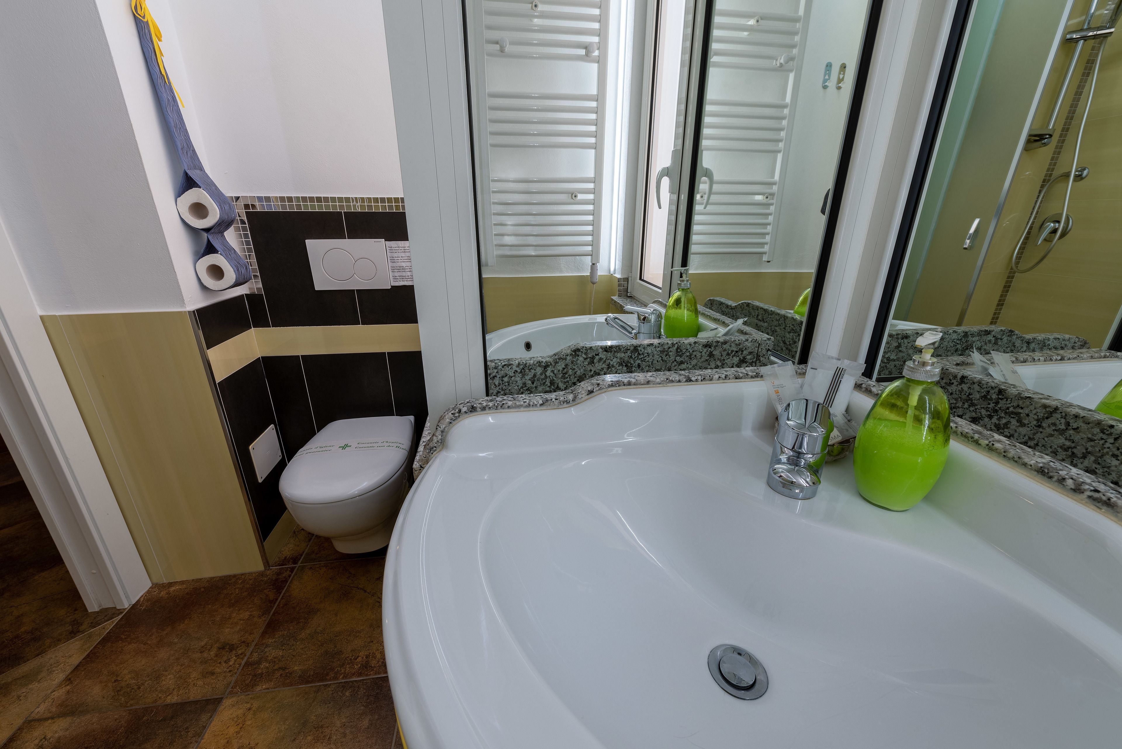 A bathroom with a white sink, a toilet, and a shower.