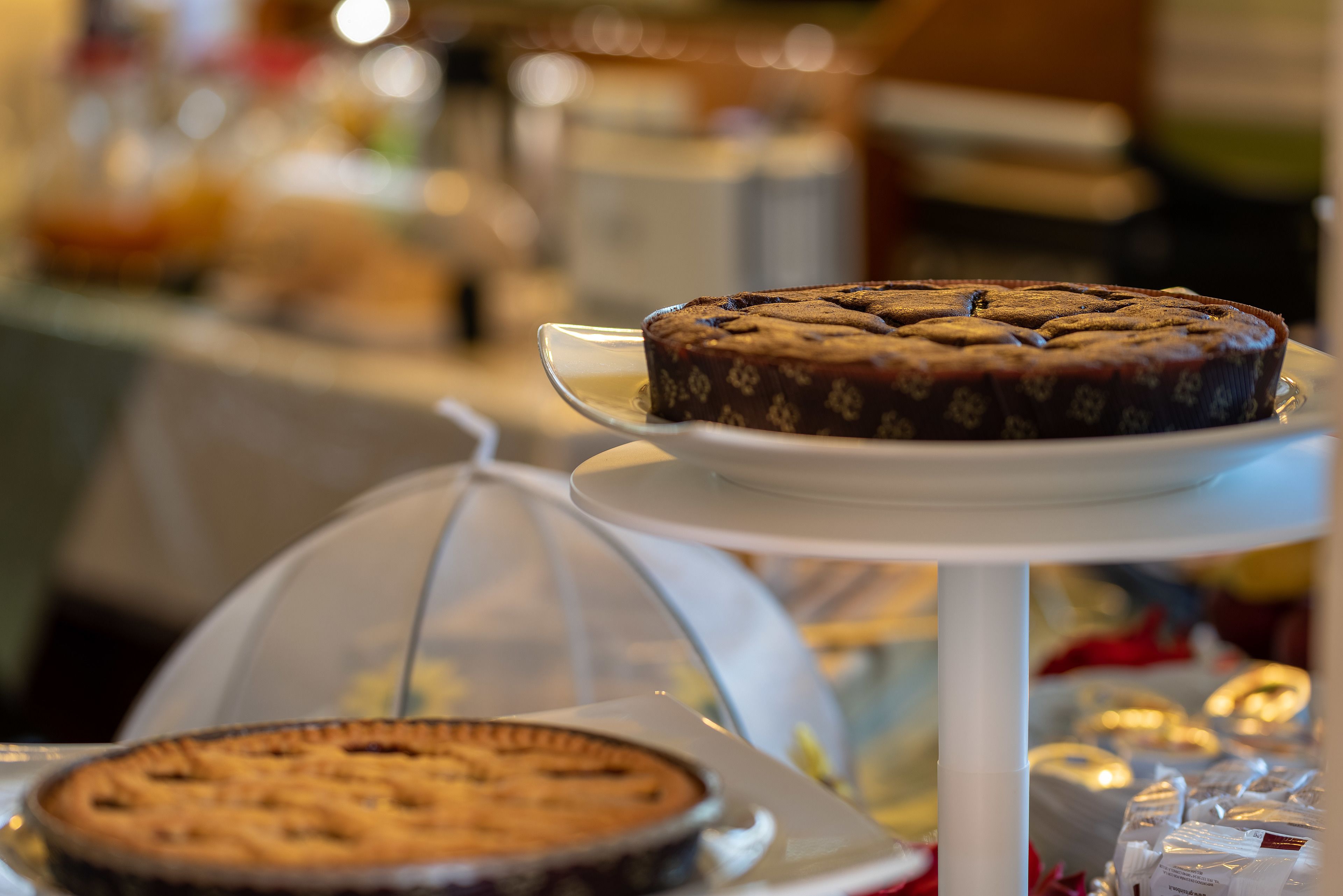 Et dessertdisplay med kager på hvide piedestaler.