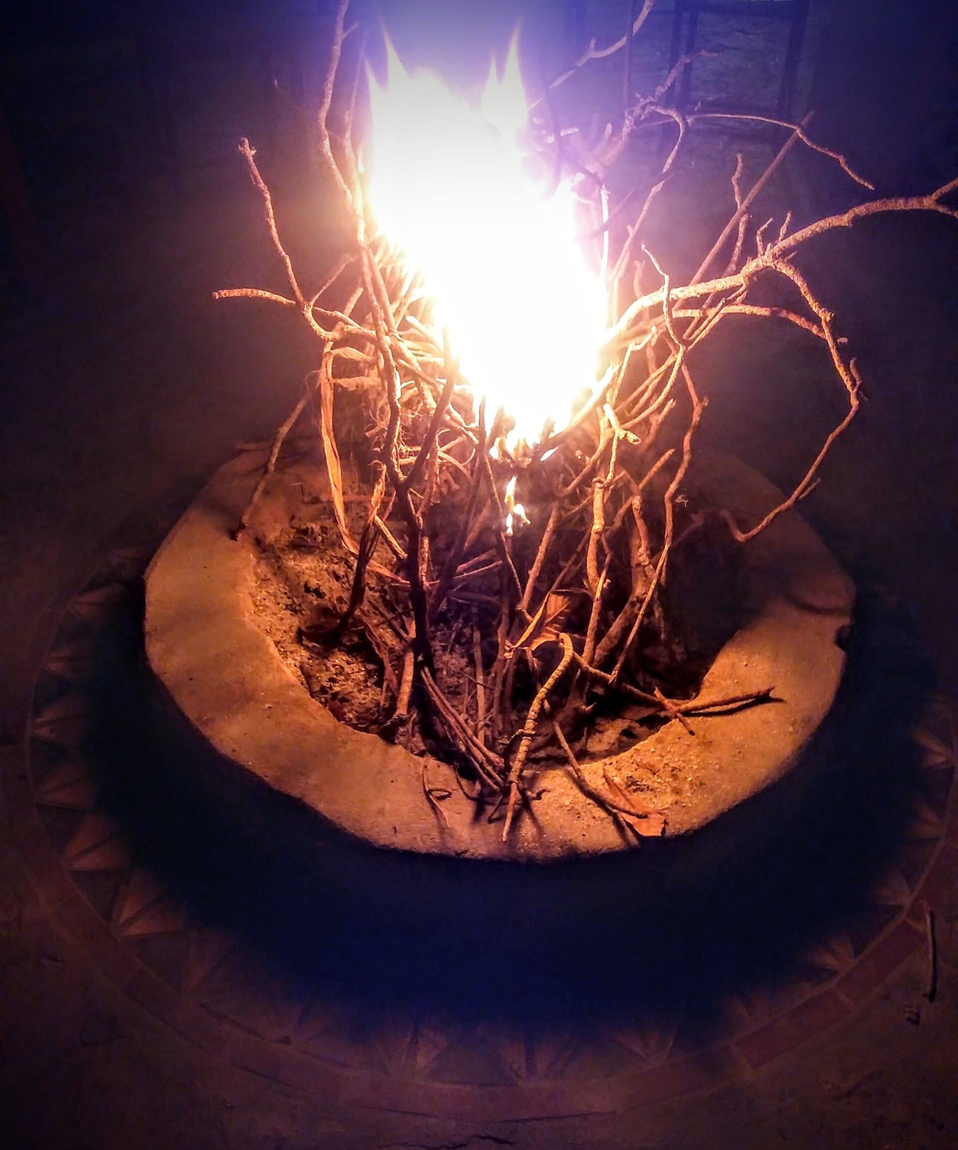A campfire in a circular stone fire pit.