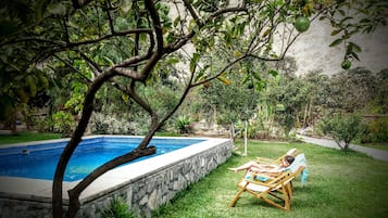 Alberca al aire libre y camastros
