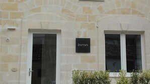 Un edificio in pietra con due finestre e un cartello con su scritto "Lamin".