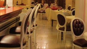 A dining area with a long table, chairs, and a bar counter.