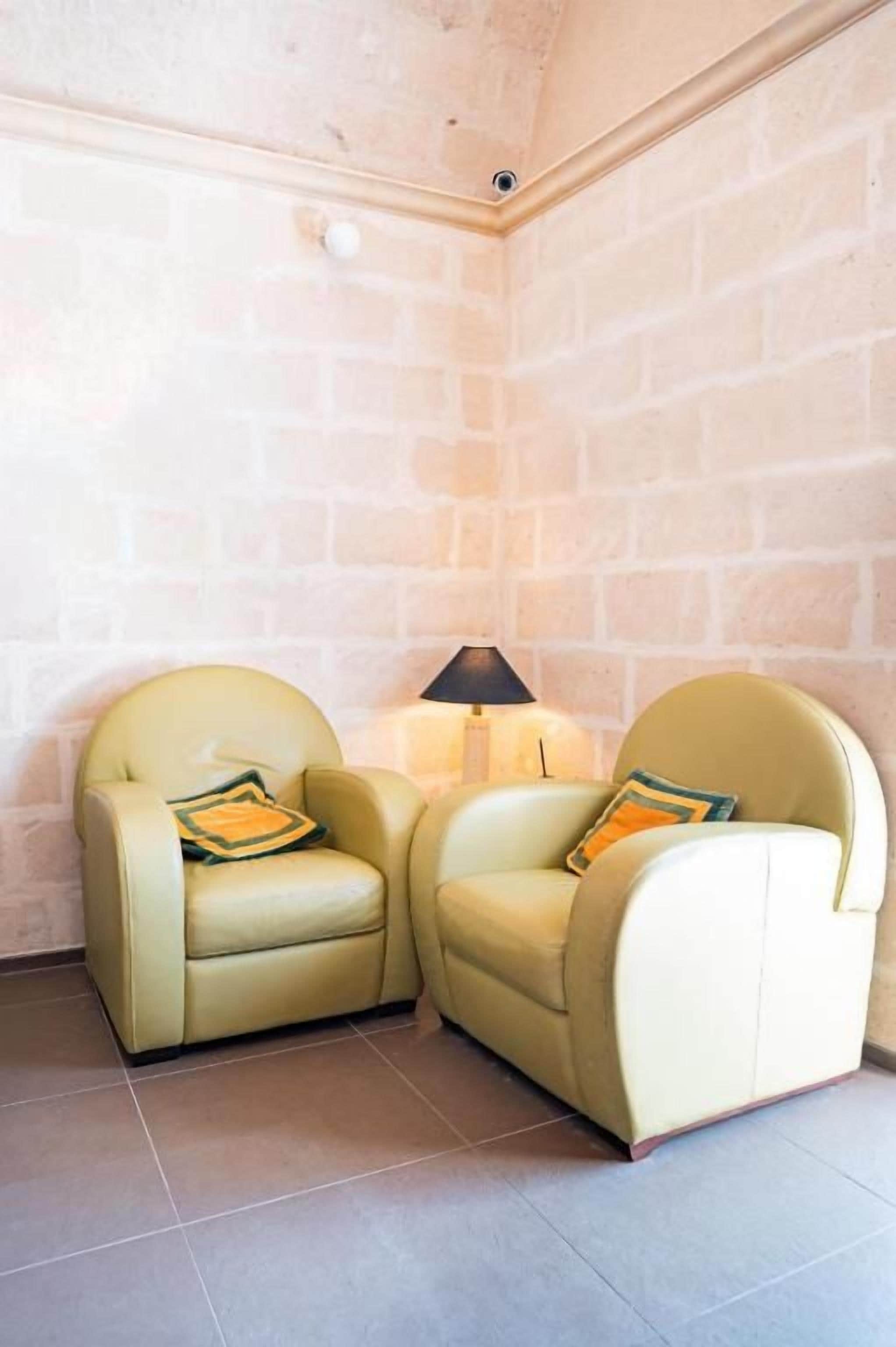 A corner room with two armchairs and a table lamp.