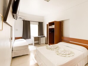 A hotel room with a bed, a desk, and a wardrobe. - Hotel Brasil (Penha)