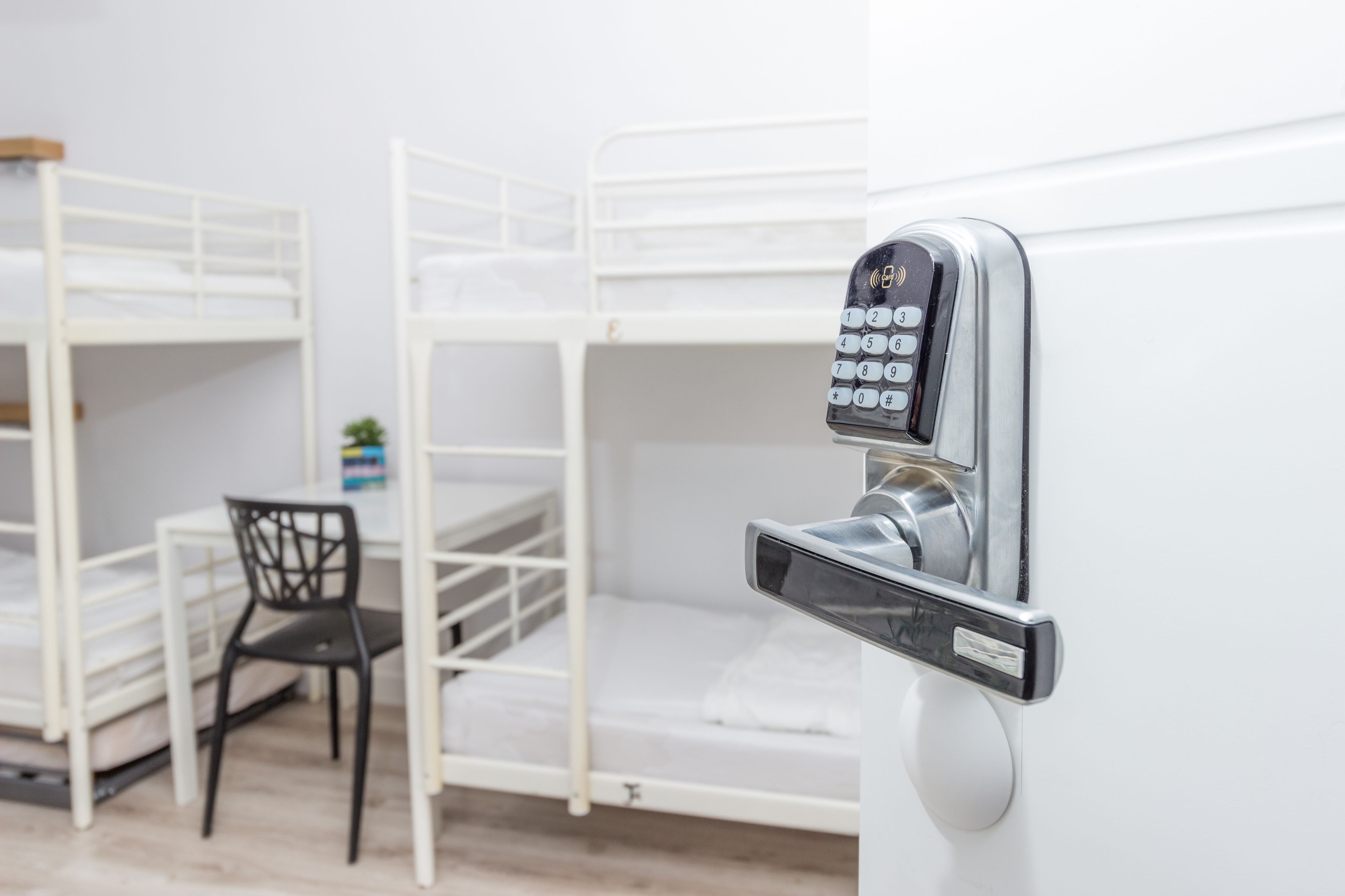 A bunk bed with a built-in desk and chair, and a keypad lock on the side.