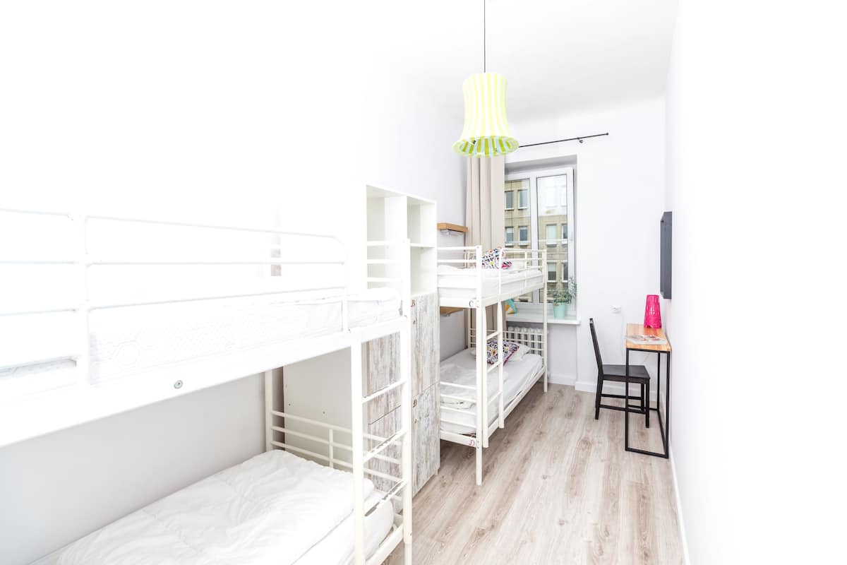 Une chambre avec des lits superposés, un bureau et une chaise.
