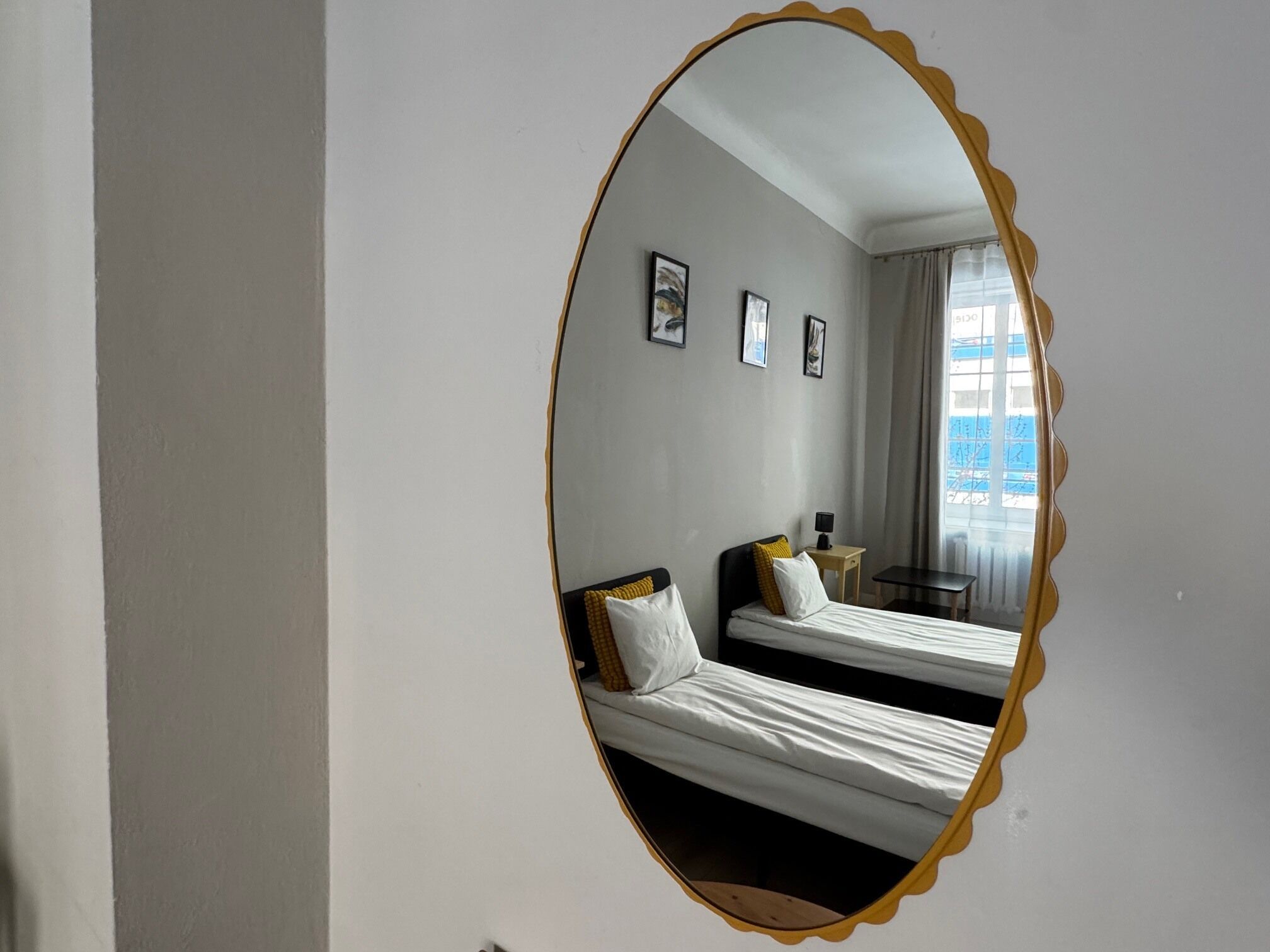 Una habitación de hotel con una cama, una mesita y un espejo.