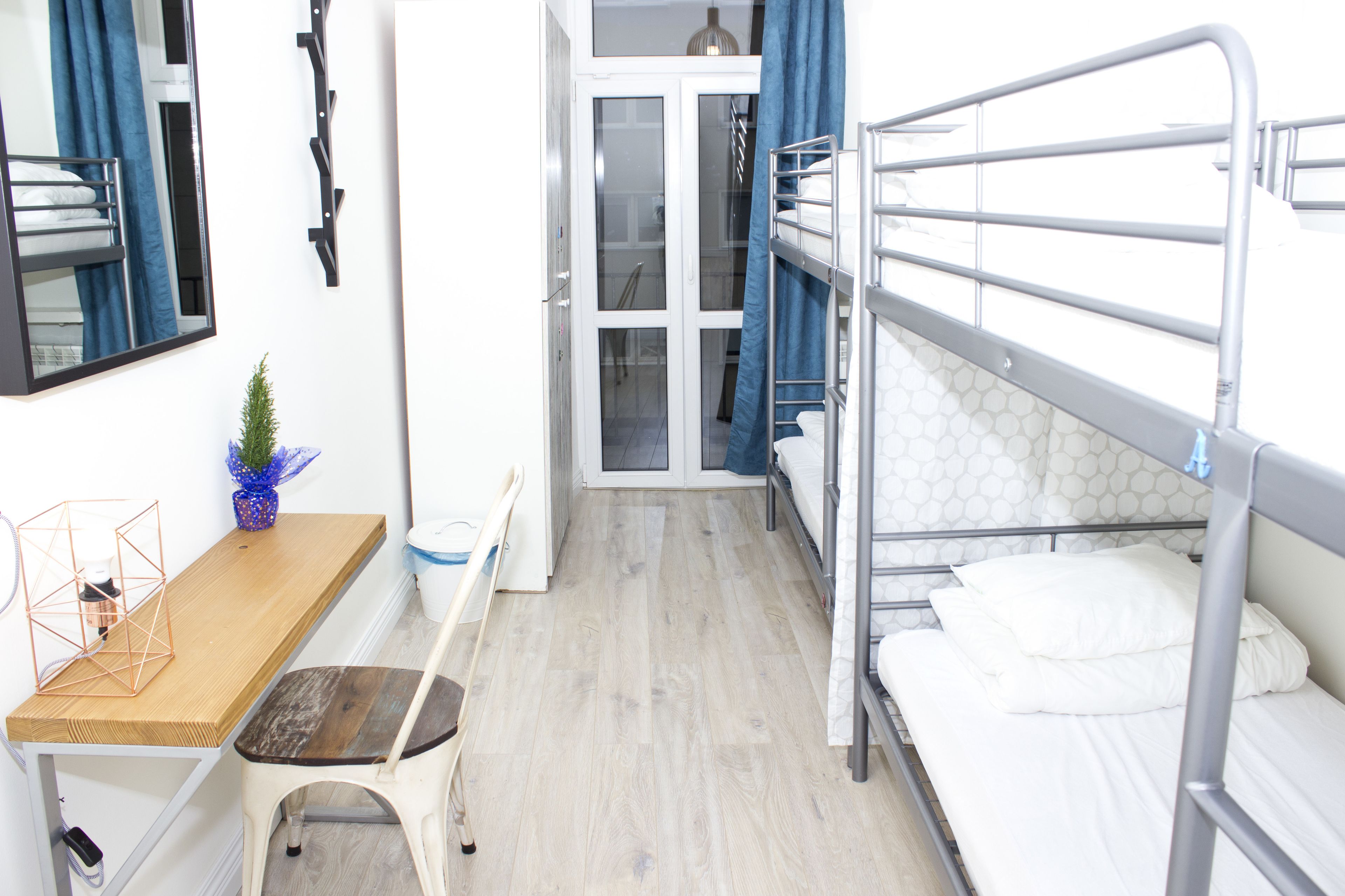 Habitación pequeña con literas, un escritorio y una silla.