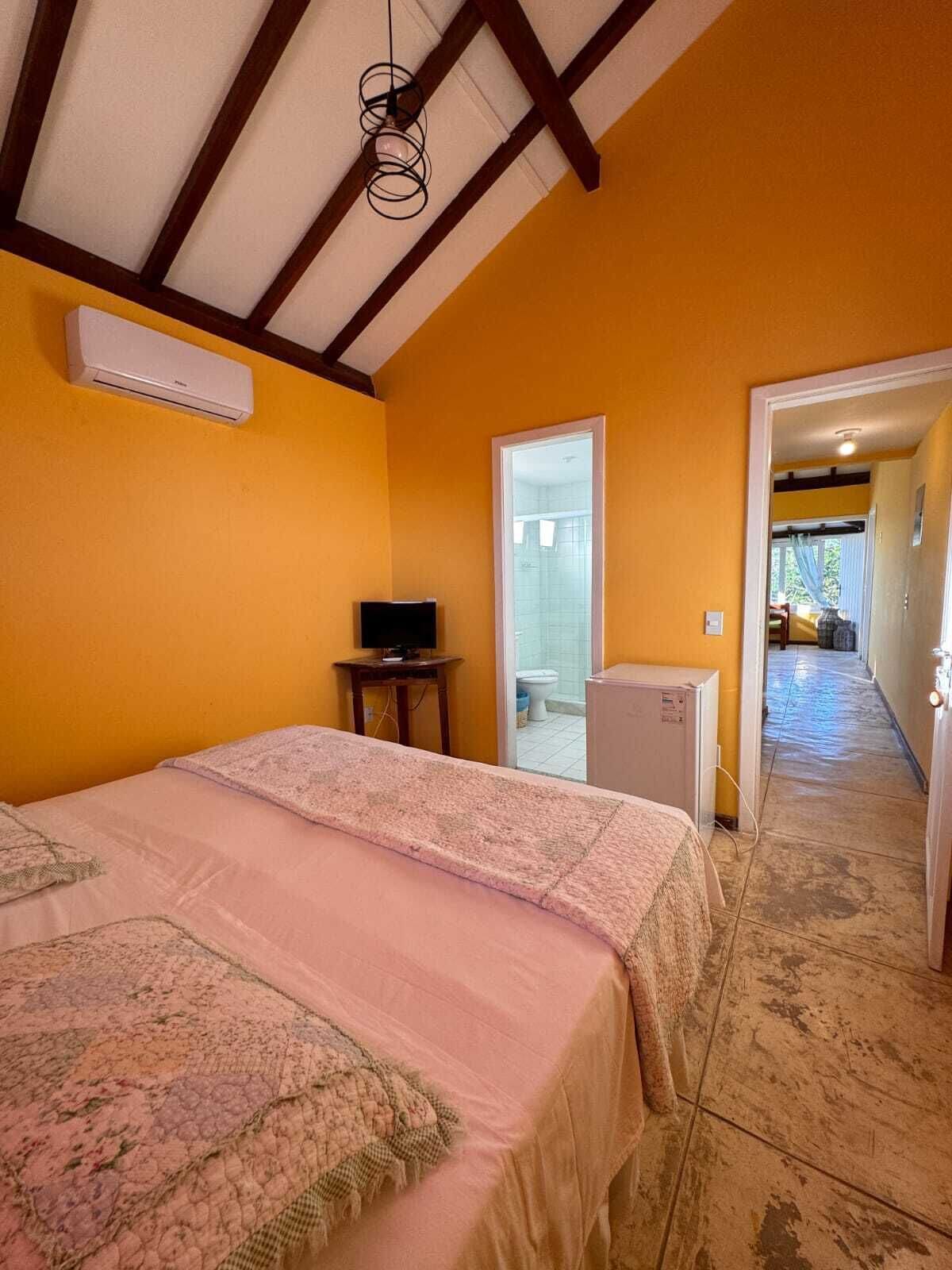 Un dormitorio con cama, televisor y equipo de aire acondicionado.