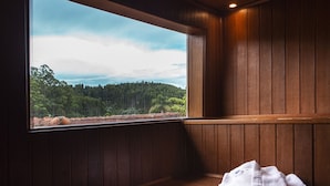 A wooden cabin with a bench and a window overlooking a forest. - Pousada das Videiras (Camanducaia)