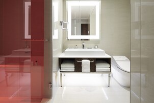 Une salle de bain moderne avec une douche à parois de verre, un lavabo blanc et des toilettes.