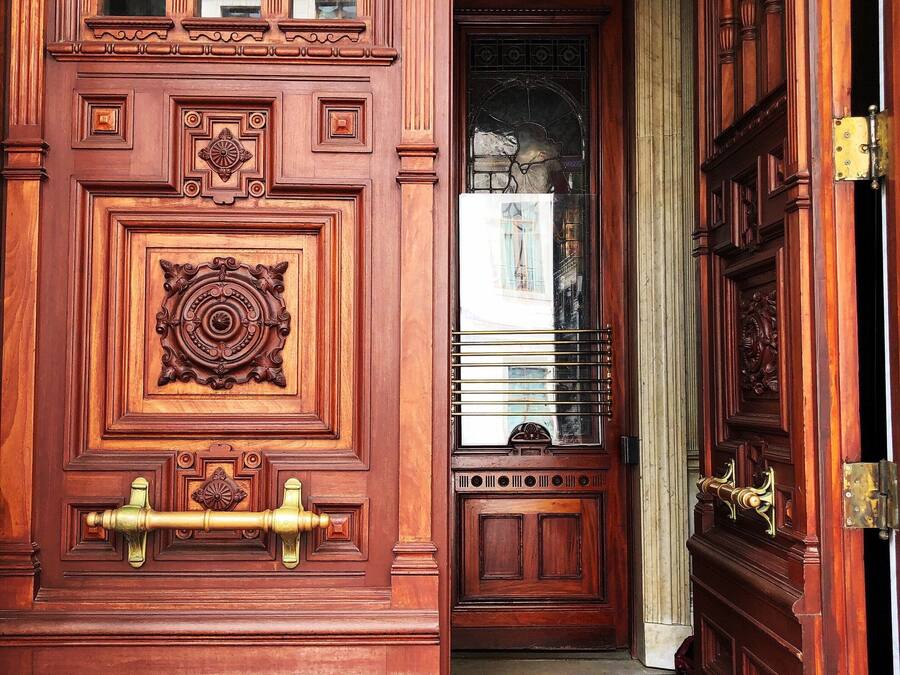 A wooden door with intricate carvings and a brass handle.